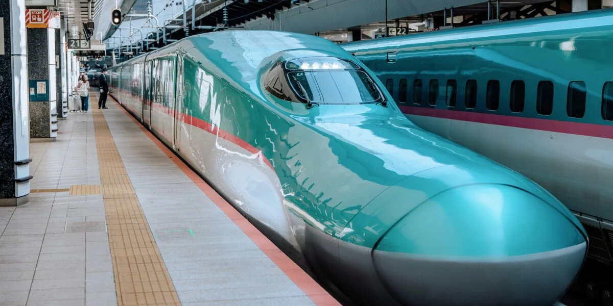 A Shinkansen bullet train speeding along tracks in Japan.