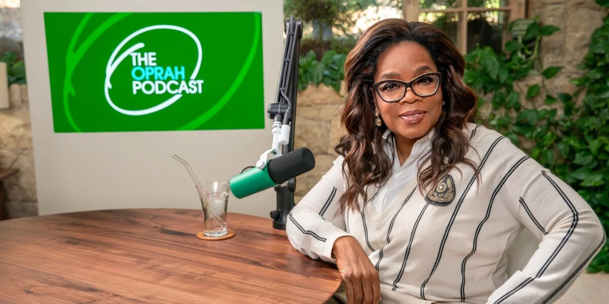 Oprah Winfrey smiling and speaking into a microphone