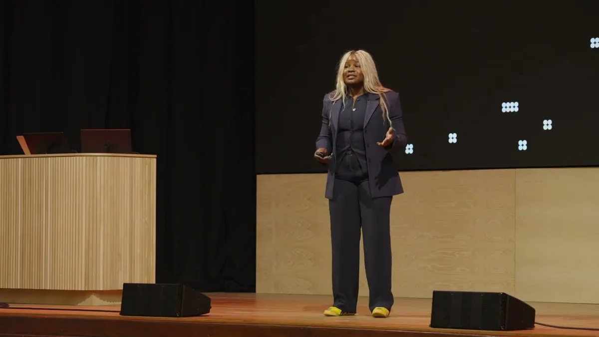 Stephanie Anani speaking on stage with 'Multiply workforce impact' title slide.