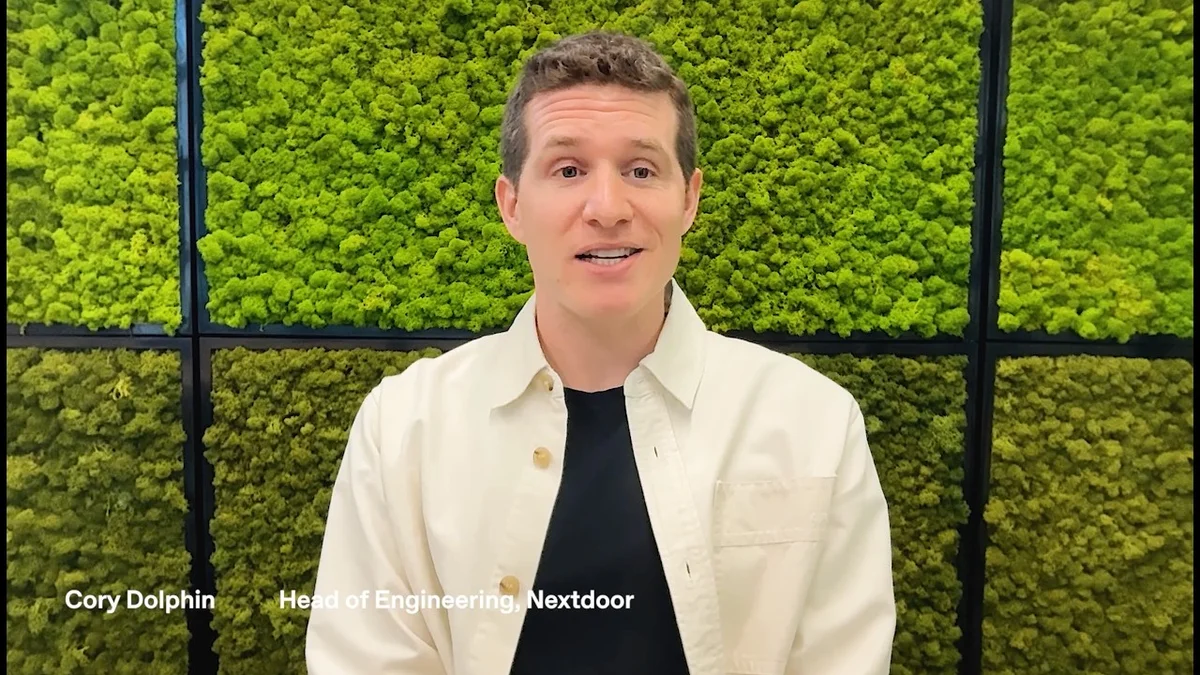 Cory Dolphin, Head of Engineering at Nextdoor, speaking in front of a green moss wall.