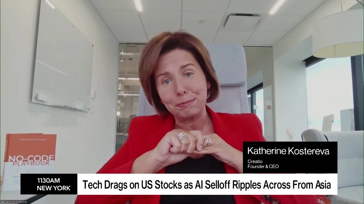 Split screen showing a female anchor on the left and a woman in a red blazer on the right, with a Bloomberg Businessweek Daily graphic.