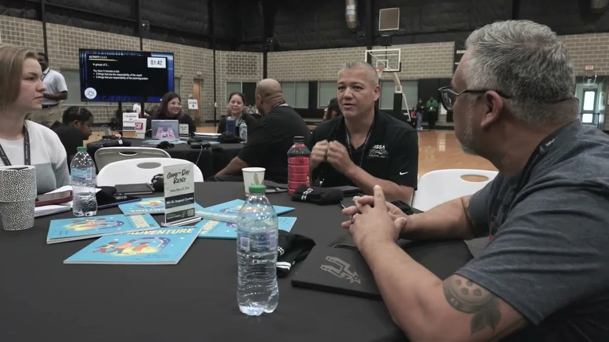 The San Antonio Spurs logo on a basketball court during an OpenAI Academy workshop.