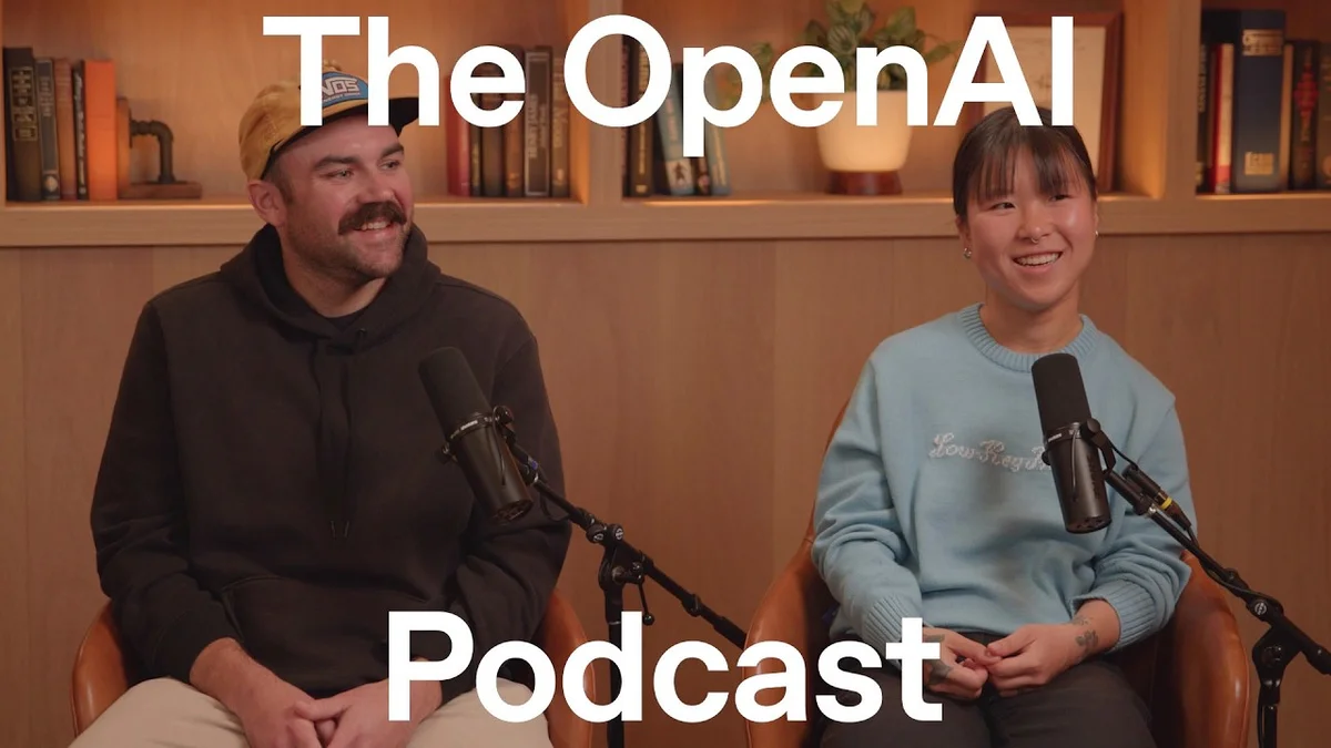 Three people sitting in chairs, two facing forward and one turned to the side, in a podcast recording setting.