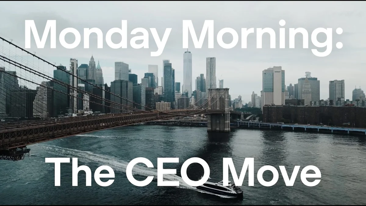 BNY CEO Robin Vince speaking in an office setting with a city skyline in the background.